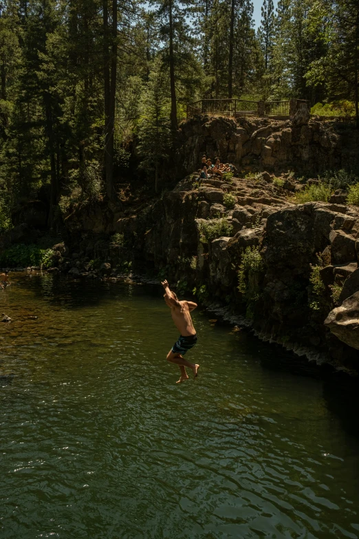 a young man is jumping into the river