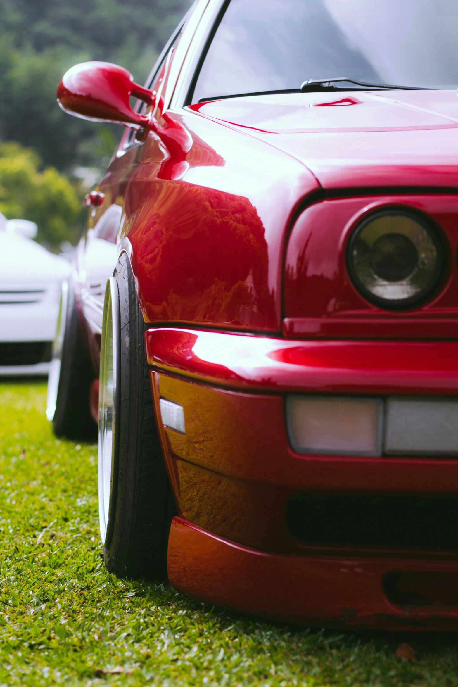 three parked cars, one red, the other white