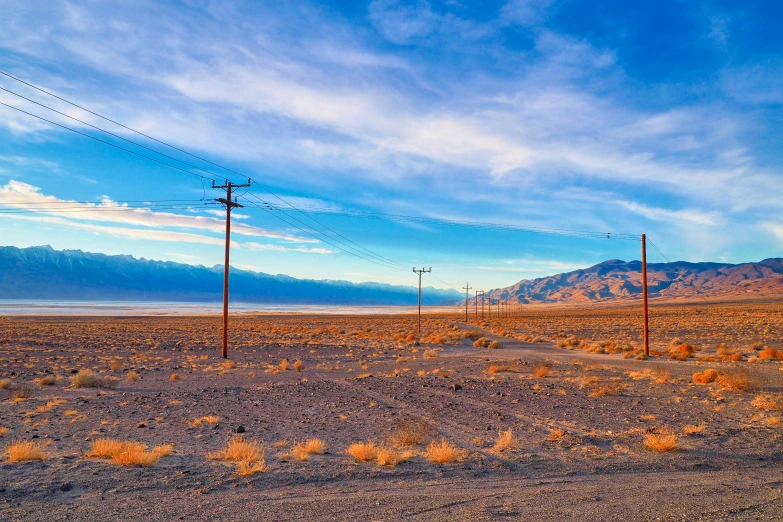 a field with telephone poles and hills