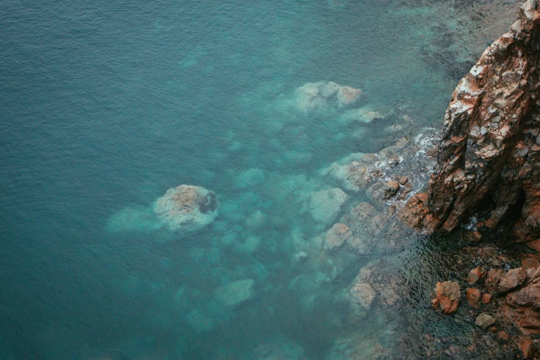 a small boat in the water near some rocks