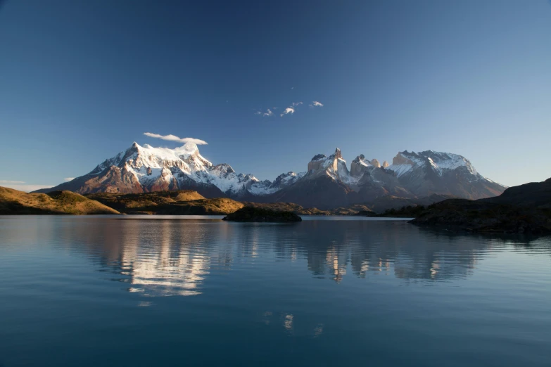 a body of water near mountains in the distance