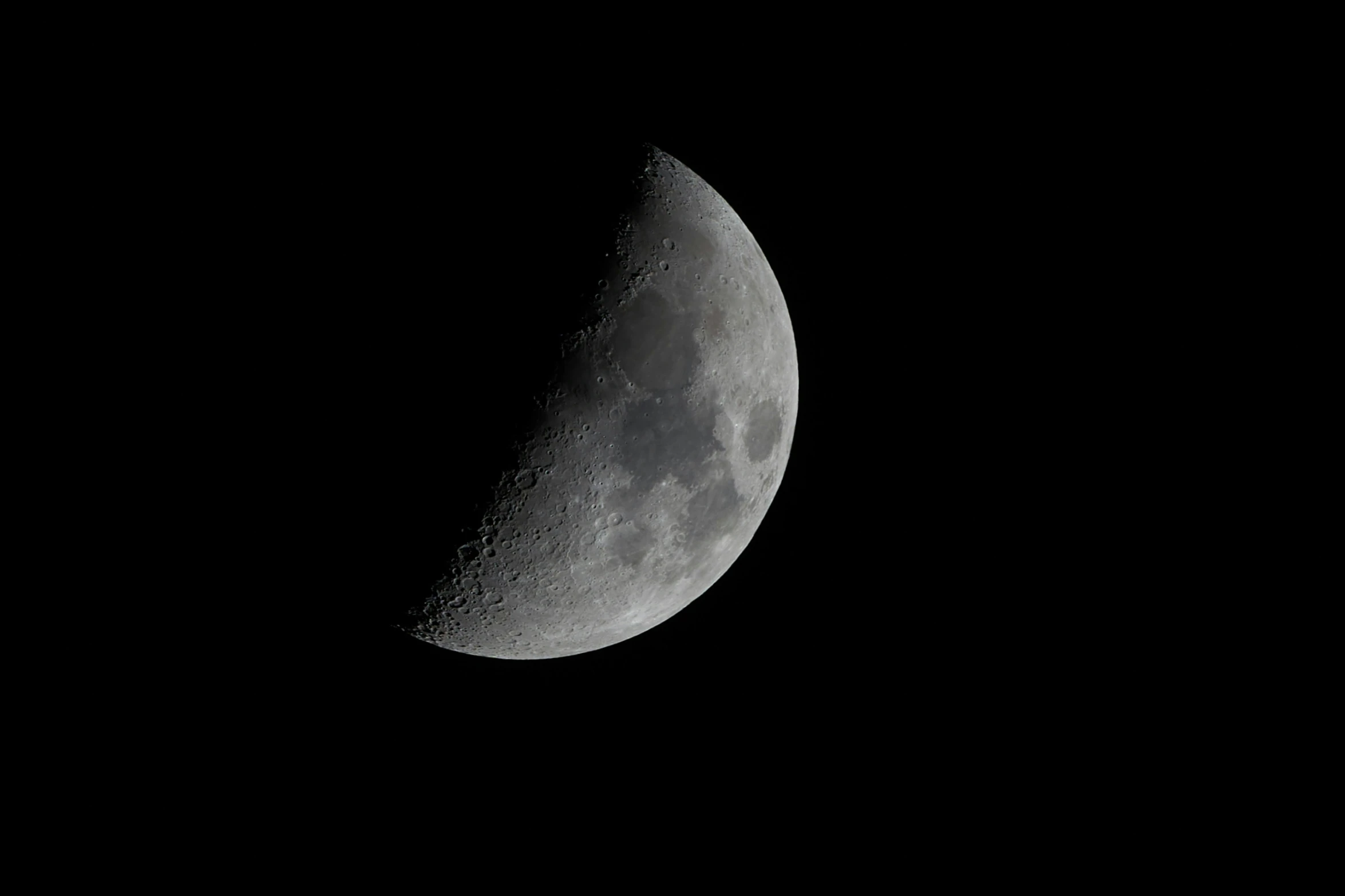 the moon is shining on a dark background