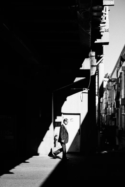 a black and white po of a man walking down the street