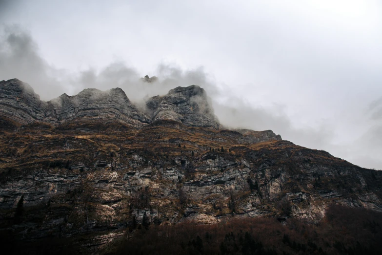 a mountain with very tall mountains and many clouds