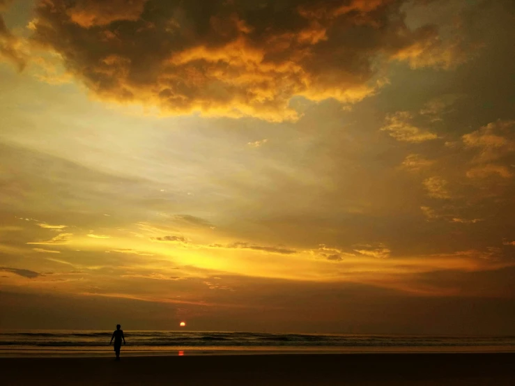 a person standing on a beach at dusk