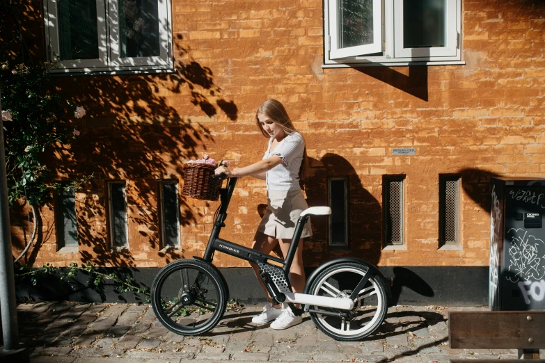 a woman walking with an open basket next to her bike