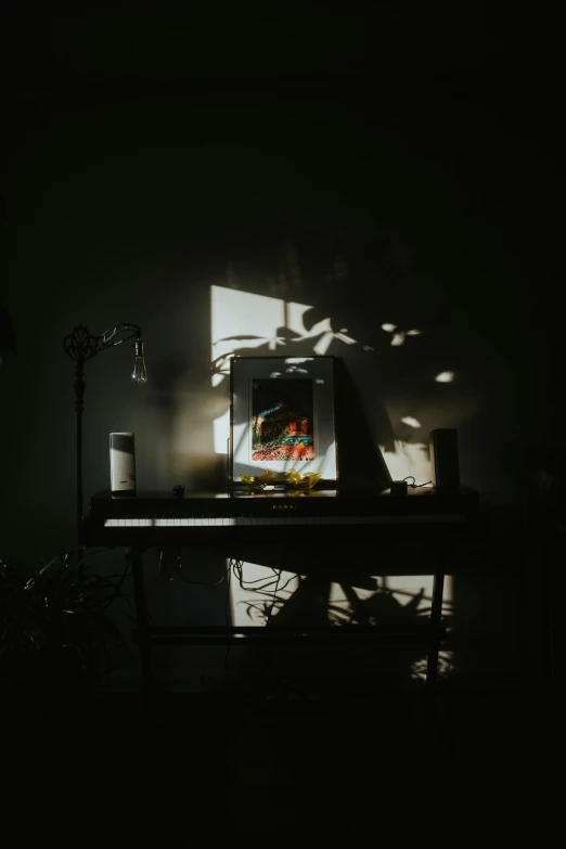 the reflection of a light on a desk shows a laptop, clock, and plants