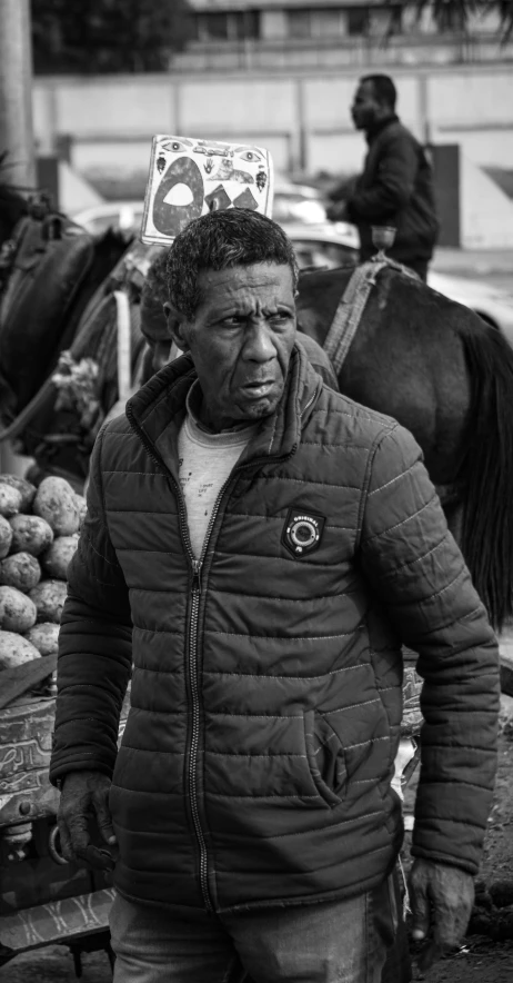 a man standing next to a horse with an upside down hat on his head