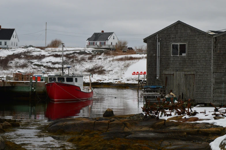 a red boat docked in front of some buildings