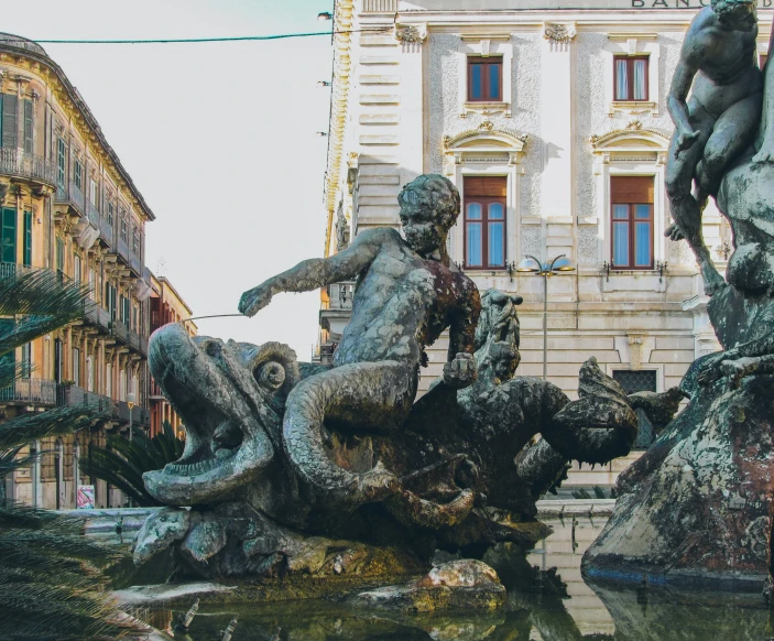 statues of men and women in the city fountain