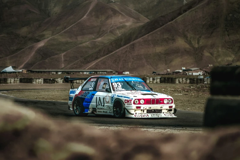 a man is driving a bmw in front of some hills