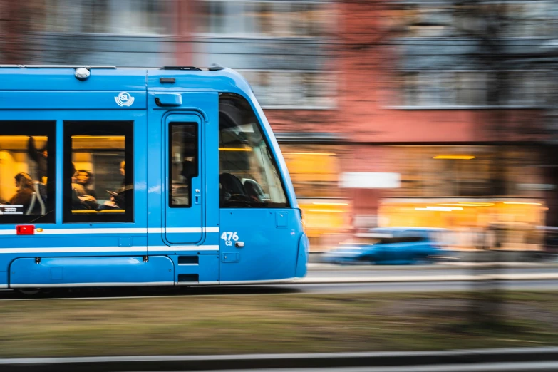 a blue public transit bus on a street