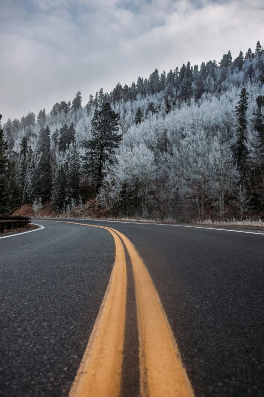 a view from the side of a car on a highway and mountains covered in frost