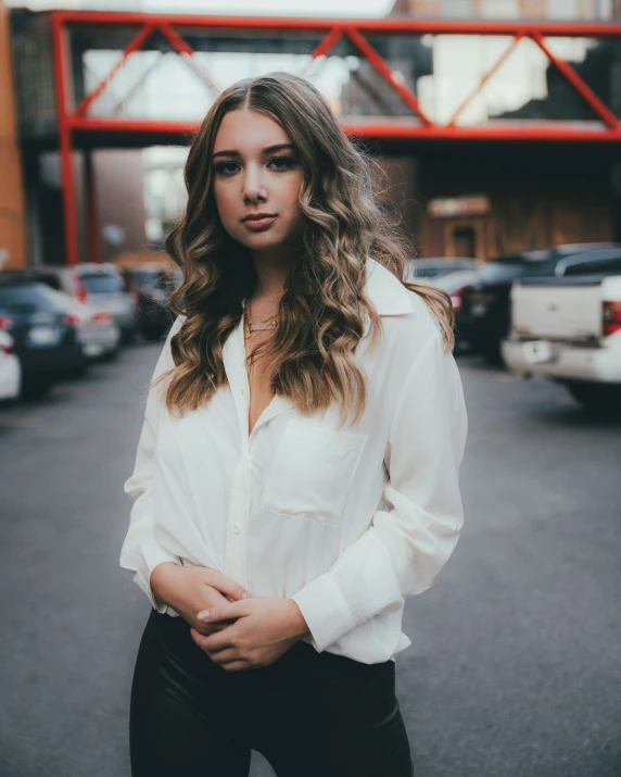 a close up of a person standing with a city street behind them