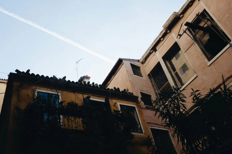 the sky is partly over a building and there are windows with bars running down each level