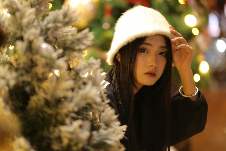 a close up of a person wearing a hat near a tree