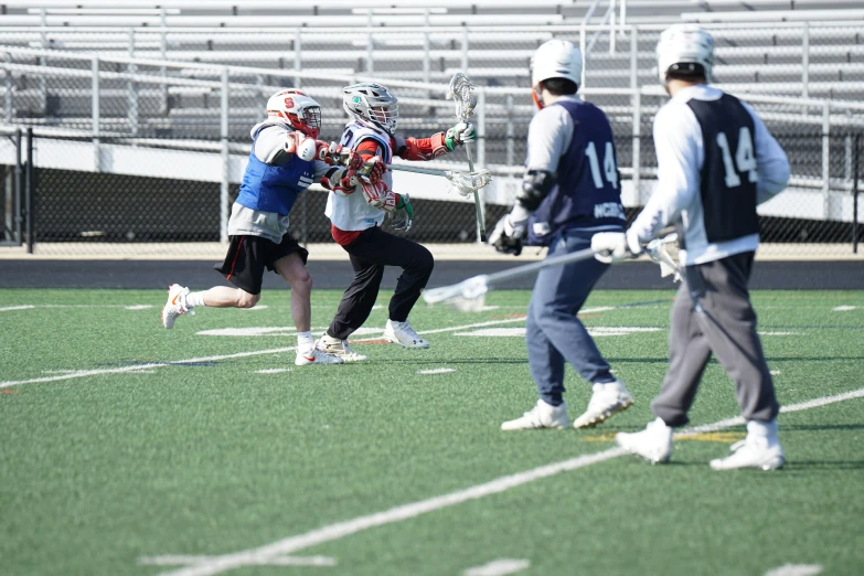 boys playing lacrosse in a large stadium