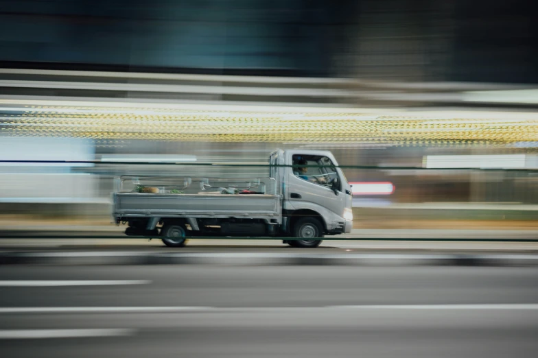 a truck driving down the road with a green roof