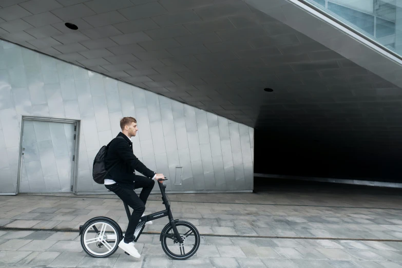 a man wearing a suit is on a tiny bike