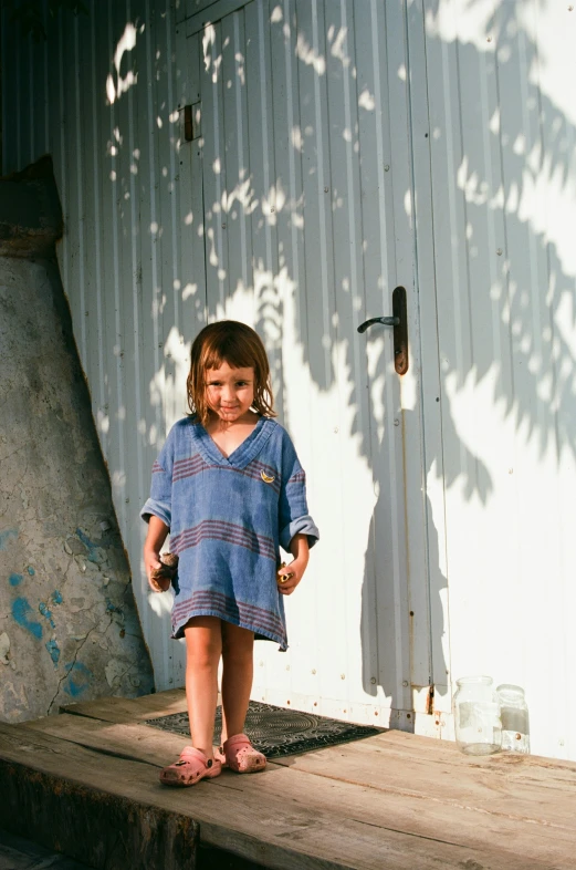 a little girl standing on a step near a building