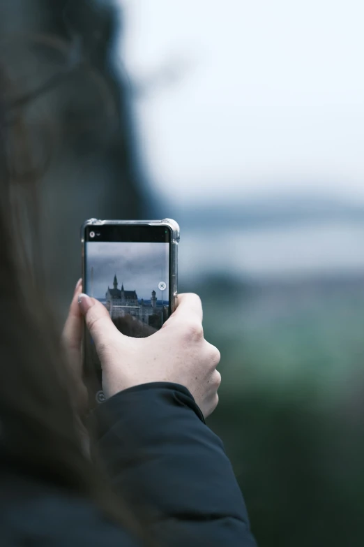 someone taking pictures of some buildings with their cell phone