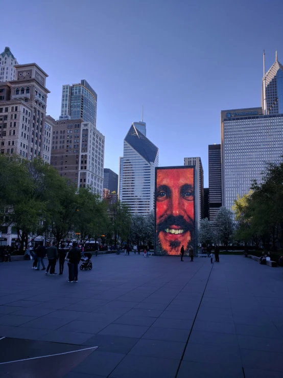 the large poster of a man is shown in the center of a large city park