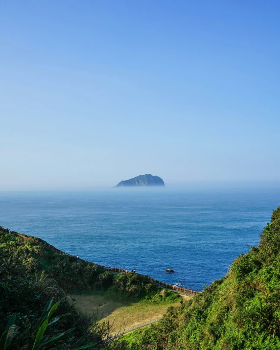 a scenic view of a body of water with a large island in the distance