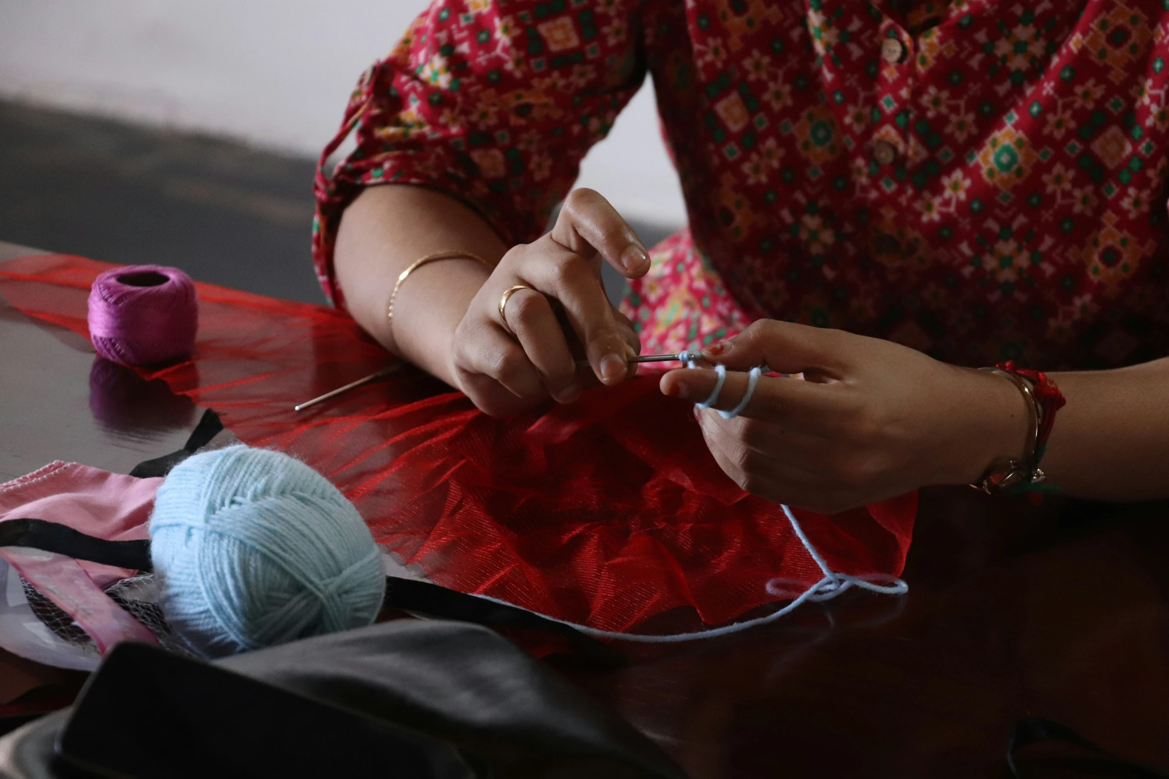 a person working on the string of a piece of cloth