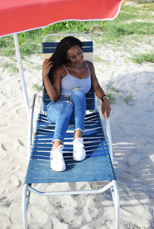 a woman sitting on a lawn chair under a shade