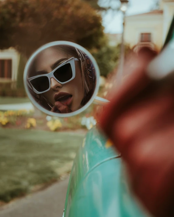 a woman in sunglasses and sun glasses looking into a mirror