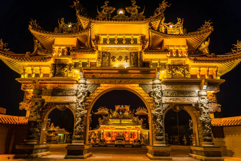 a golden gated archway lit up with lights and decorations