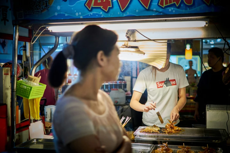 a woman and man serving food at an outdoor buffet