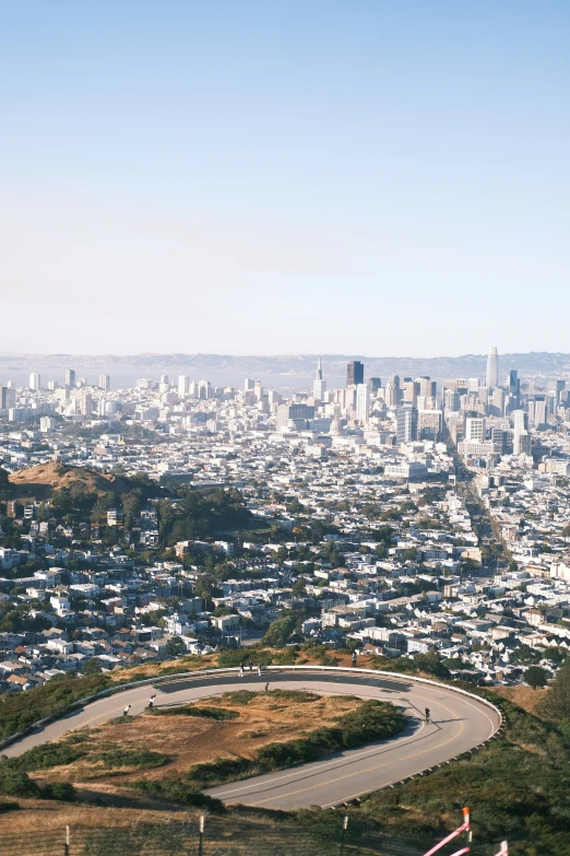 a winding city road with a skyline in the background