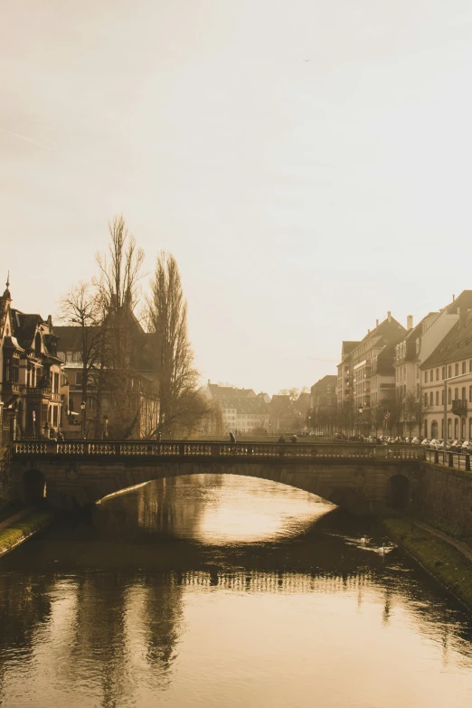 the view of an empty bridge over a canal in an old town