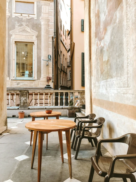 a table with four chairs around it on a stone walkway