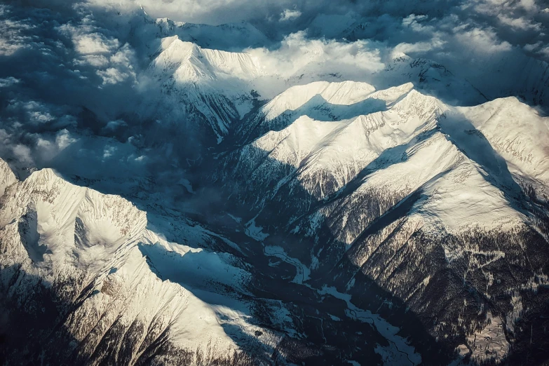 a snowy mountain range in the mountains taken from an airplane