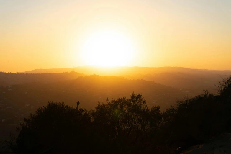 the sun is setting over a small town in the background