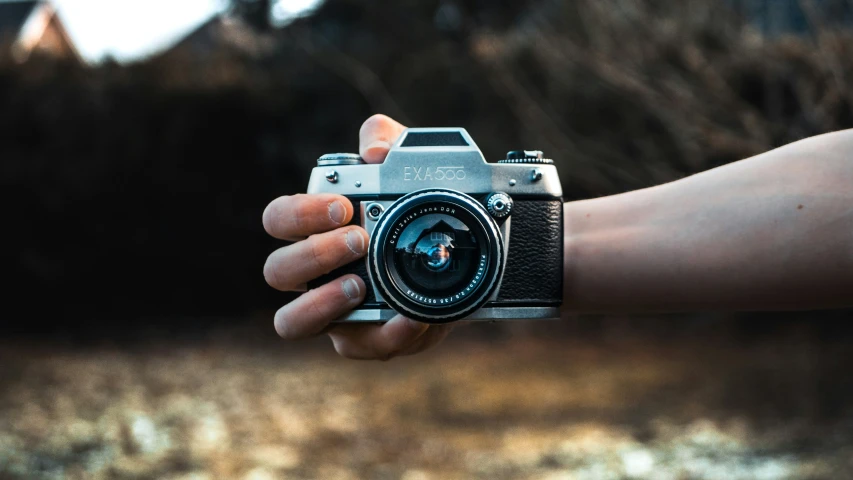 person holding a camera in their left hand