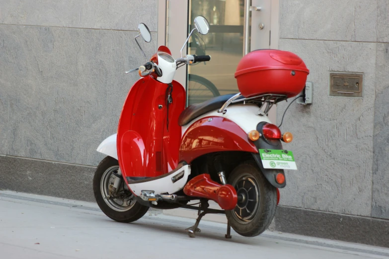 the red motorcycle is parked outside the building