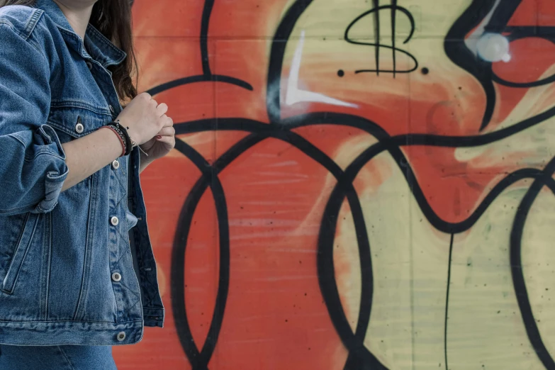 a woman standing next to a graffiti wall