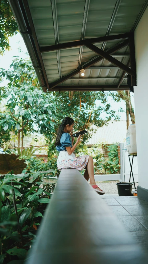 a woman sitting in the shade with her cell phone