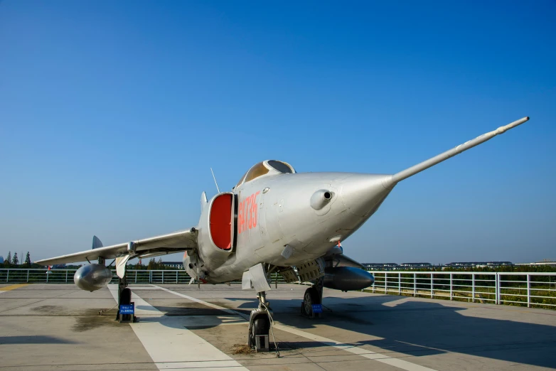 a jet airplane sits on a runway and is looking away