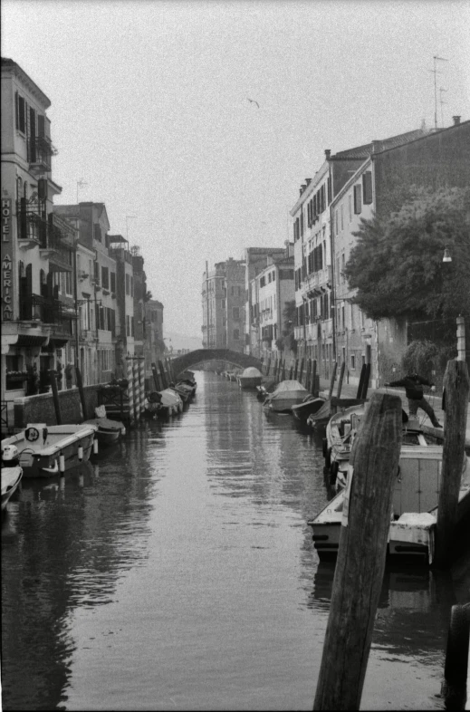 an old pograph of a small canal with boats moored