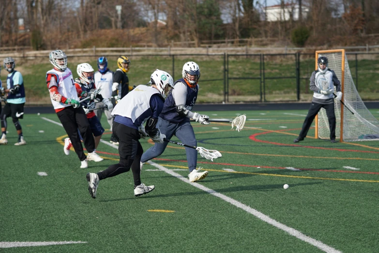 group of lacrosse players on field playing with racket