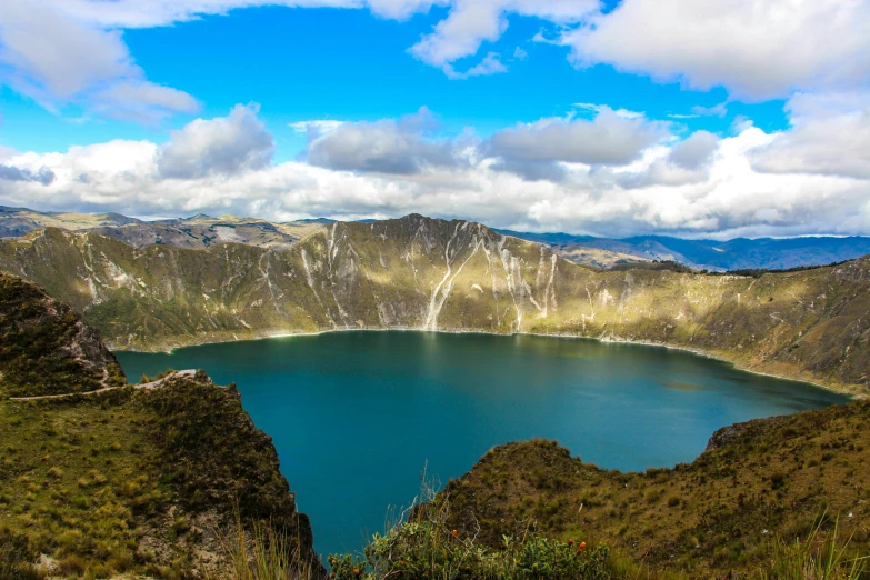 a mountain landscape with a lake surrounded by moss