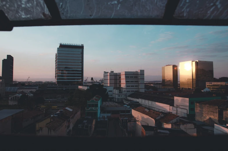 the sky is shining and the buildings are silhouetted