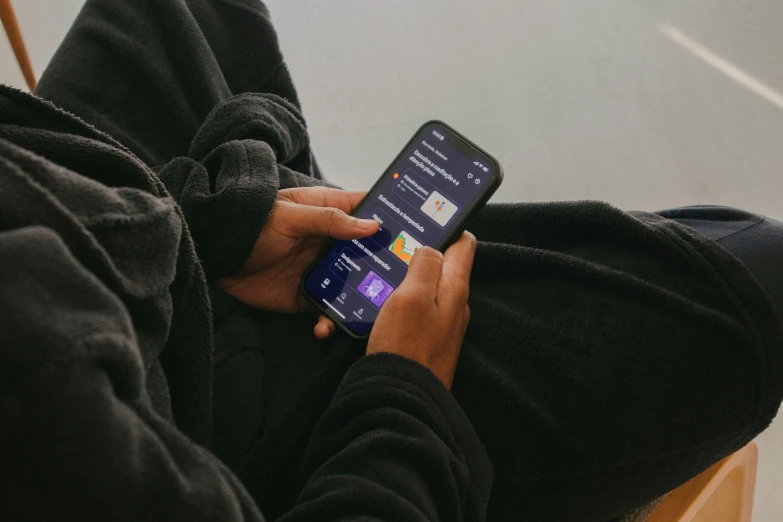 a person holding an electronic device while sitting