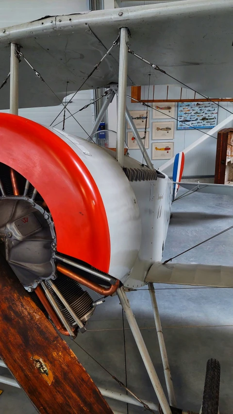 a small plane sits on display in a museum