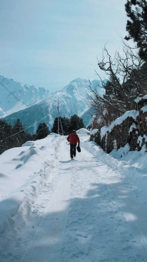 a person walks through the snow toward mountains