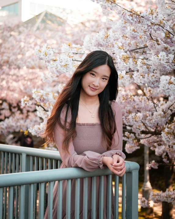 a girl standing by flowers on a bridge